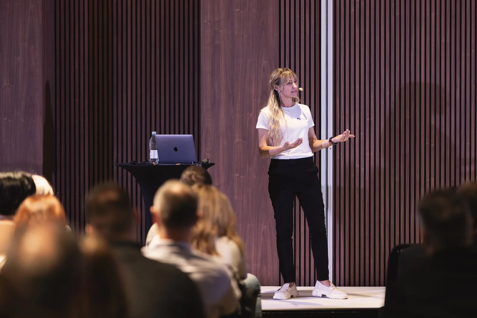 Odeta Isevičiūtė speaking on stage at a technology conference