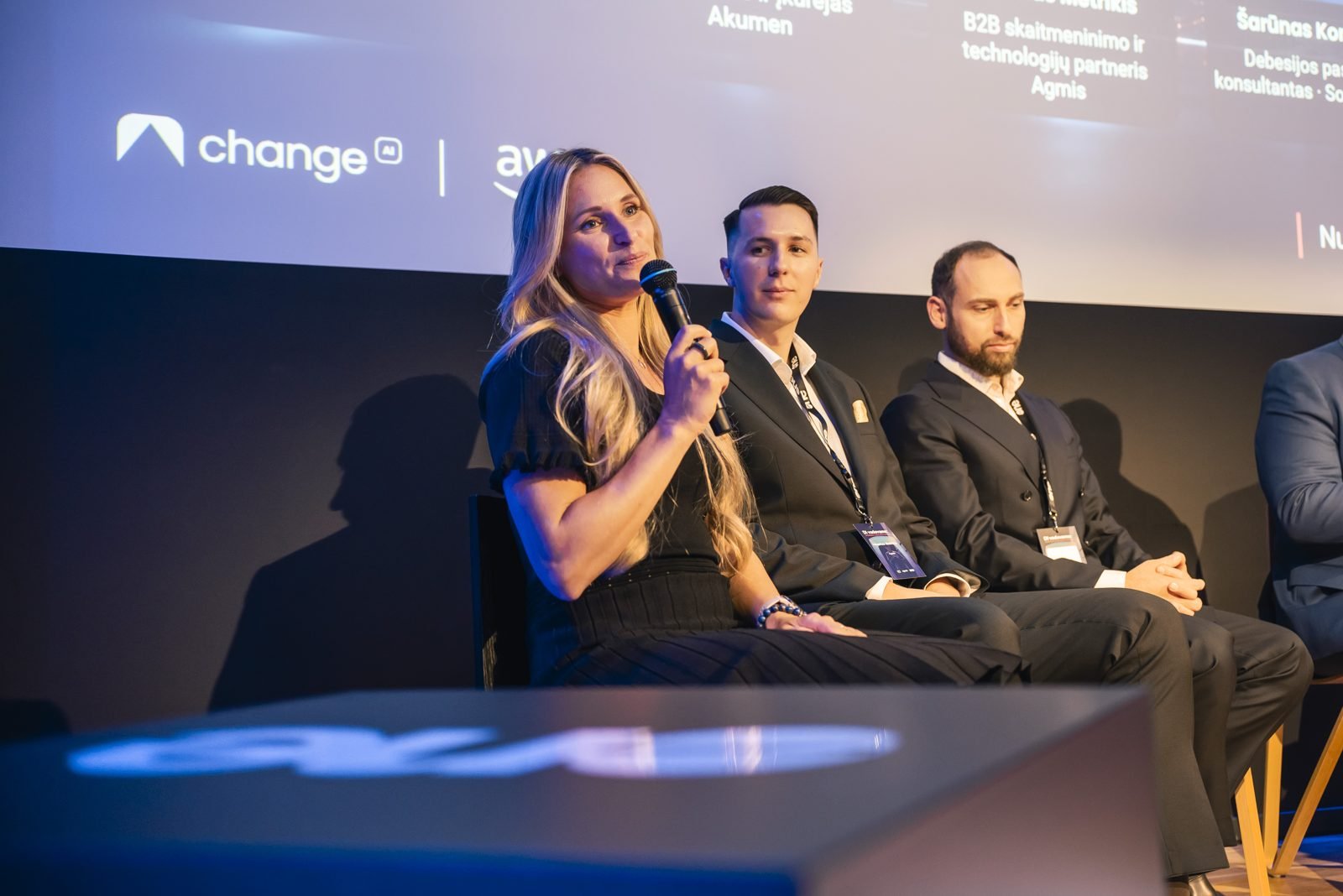 Odeta Isevičiūtė speaking on the panel, seated beside other speakers at the Agmis and SoftwareOne event.